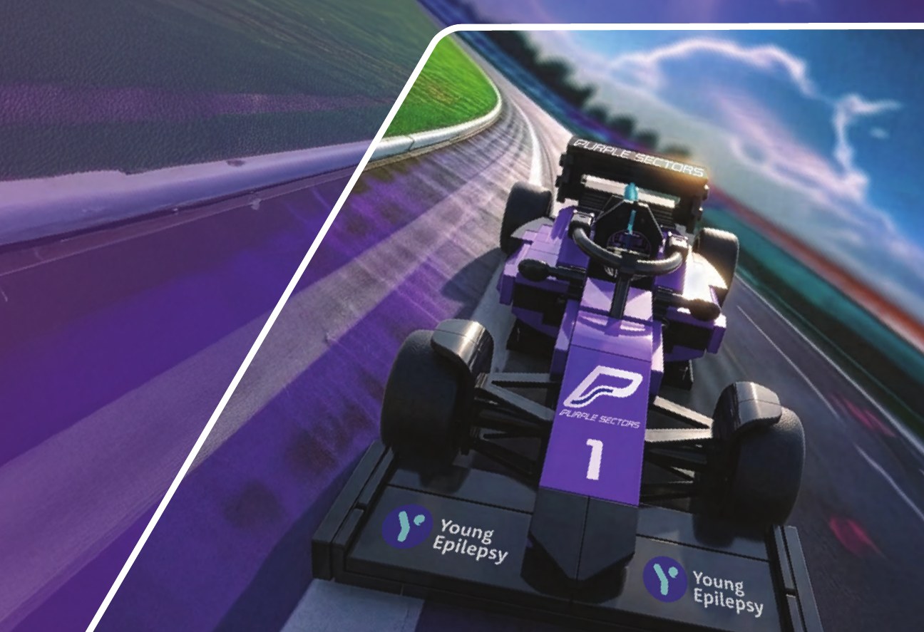 The purple, number 1 Purple Sectors Brick IT race car on a display stand, on a track backdrop.